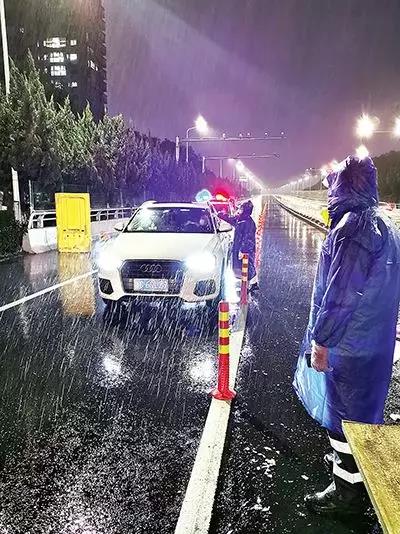 凌晨，東甌大橋卡點(diǎn)處，永嘉縣黨員干部頂風(fēng)冒雨、在嚴(yán)寒中牢牢值守。（　圖片由浙江省溫州市委組織部提供）